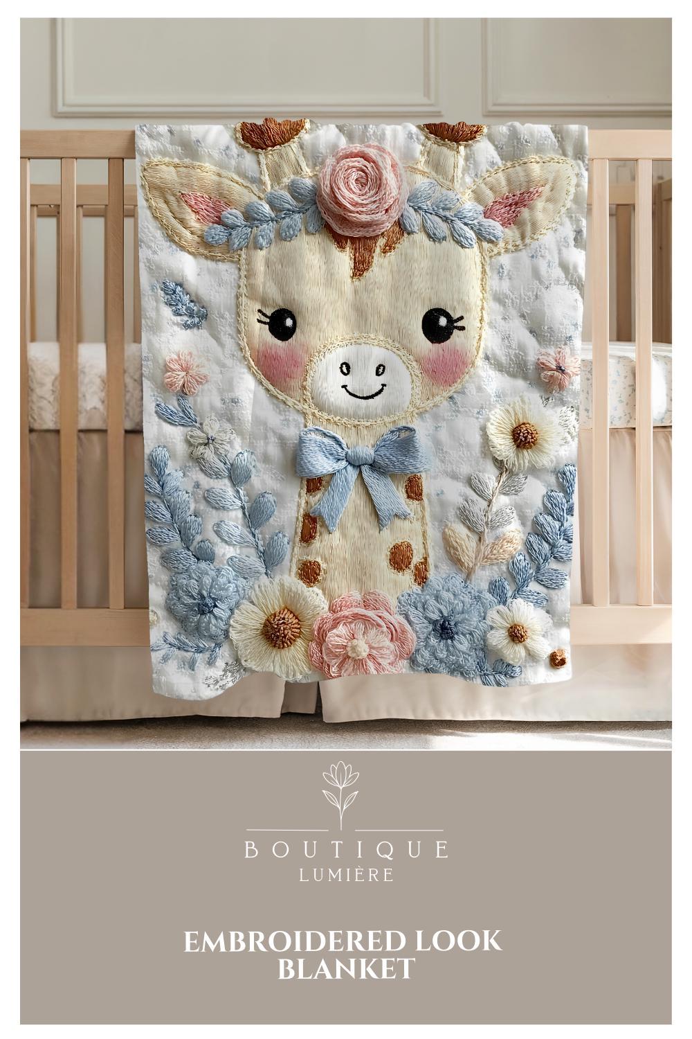 Embroidered-look giraffe blanket with floral crown and soft blue–peach details. Cozy fabric, gentle colors — a sweet newborn gift and neutral nursery decor.