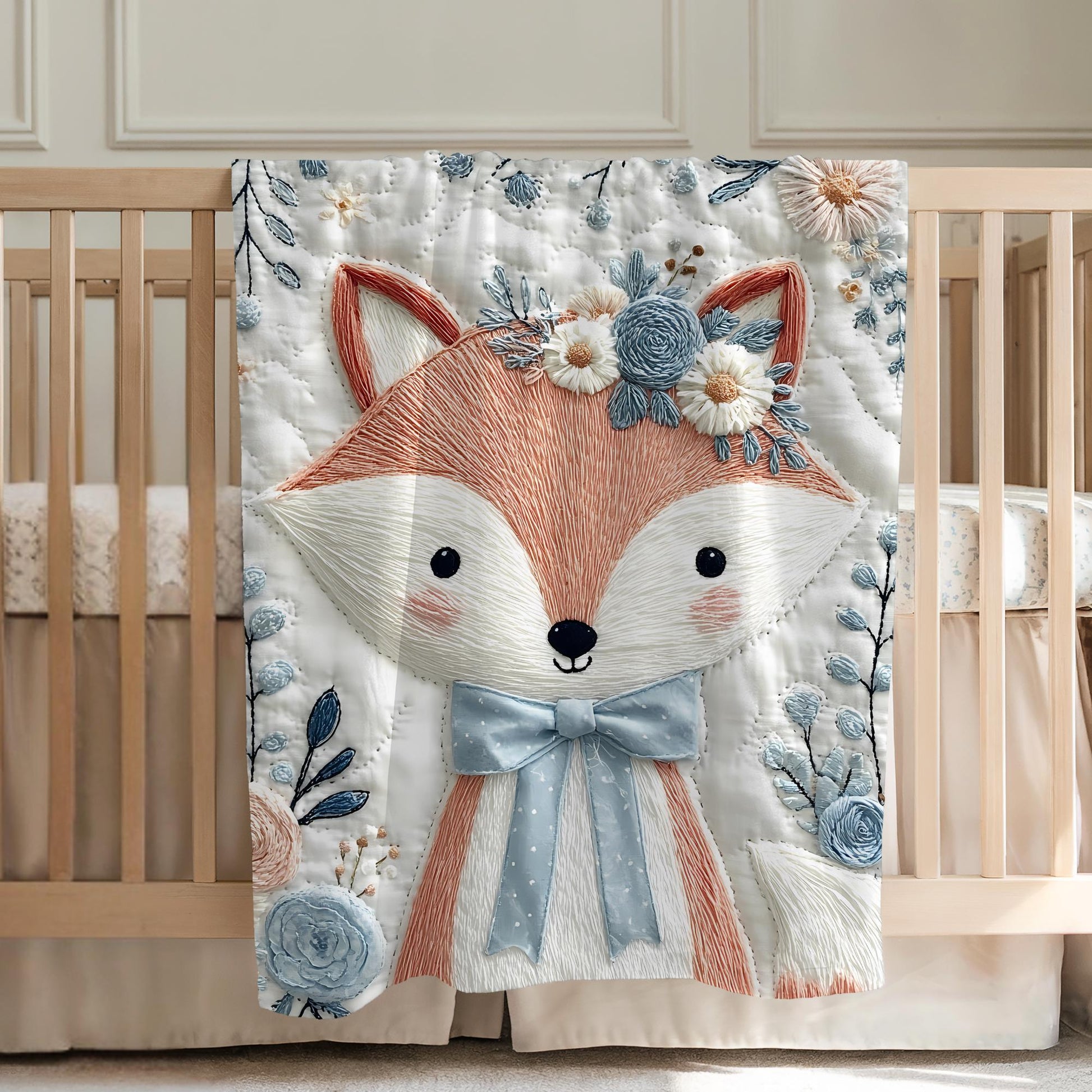 Embroidered-look fox baby blanket with soft floral crown and gentle blue–peach stitched details on a neutral background.