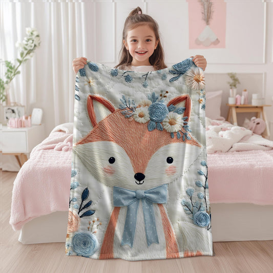 Embroidered-look fox baby blanket with soft floral crown and gentle blue–peach stitched details on a neutral background.