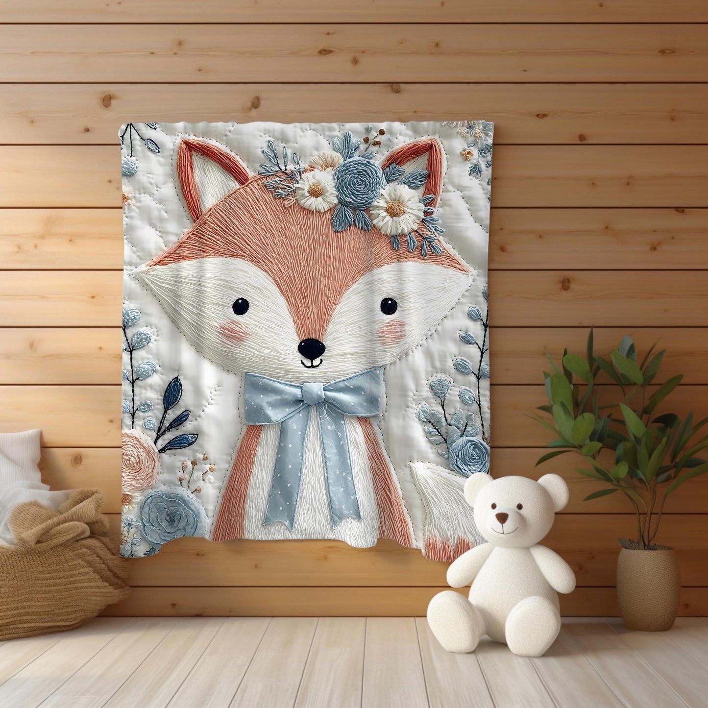 Embroidered-look fox baby blanket with soft floral crown and gentle blue–peach stitched details on a neutral background.