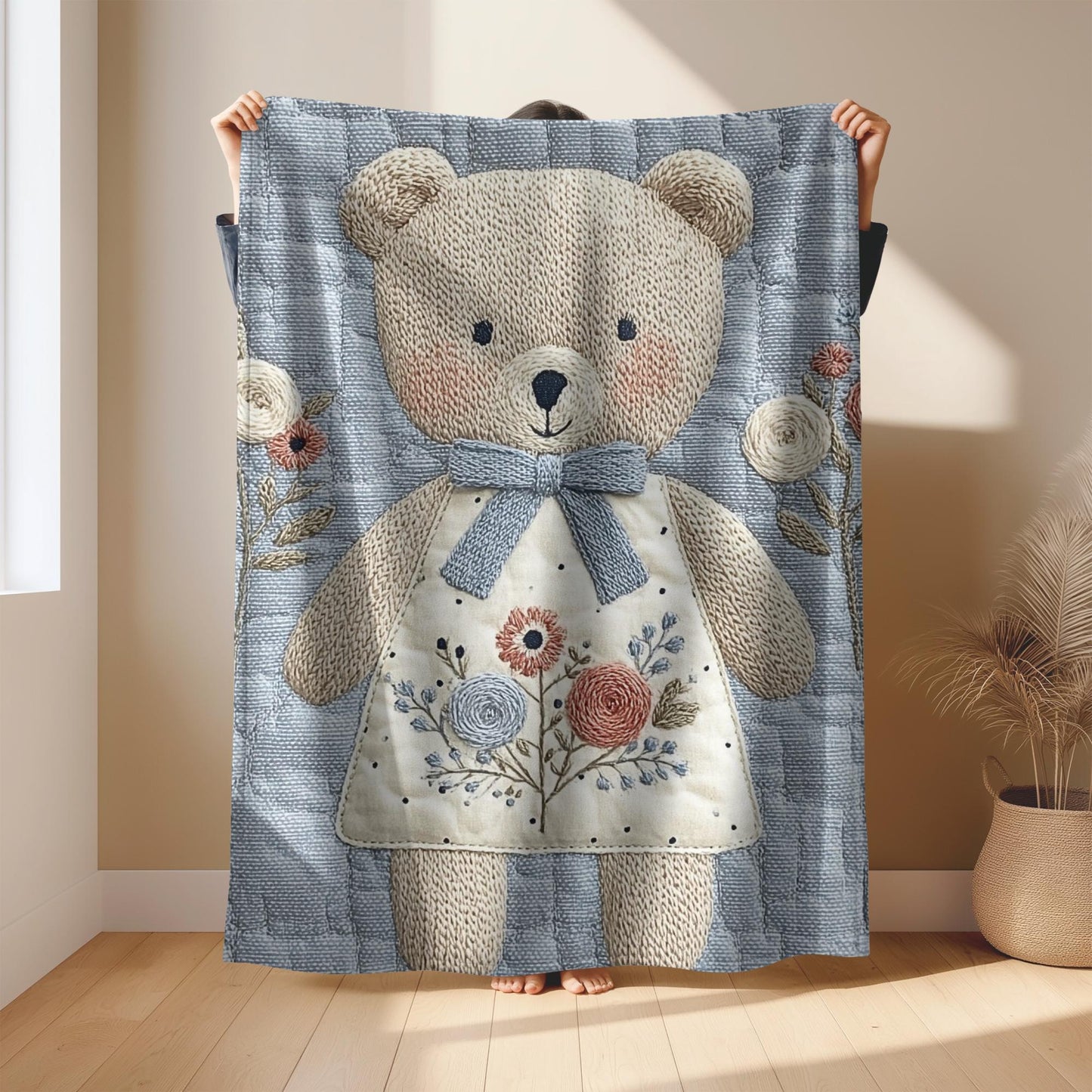 Embroidered-look teddy bear girl baby blanket with floral details on a soft blue quilted background.