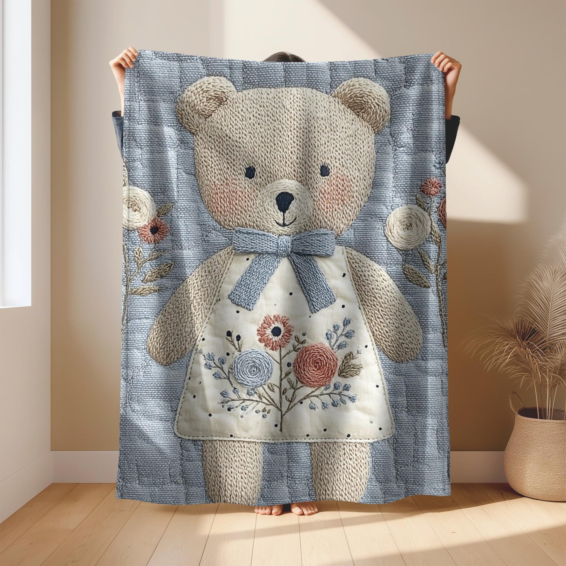 Embroidered-look teddy bear girl baby blanket with floral details on a soft blue quilted background.