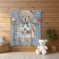 Embroidered-look teddy bear girl baby blanket with floral details on a soft blue quilted background.