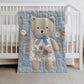 Embroidered-look teddy bear girl baby blanket with floral details on a soft blue quilted background.