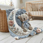 Soft embroidered-look teddy bear baby blanket with pastel florals. Neutral tones, cozy fabric — a boutique newborn gift for calm, modern nursery decor.