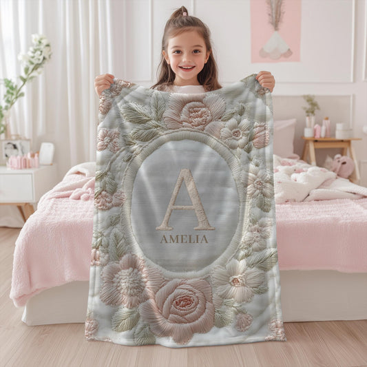 Elegant personalized baby blanket with floral monogram in an embroidered-look style. A timeless, meaningful gift for newborns.