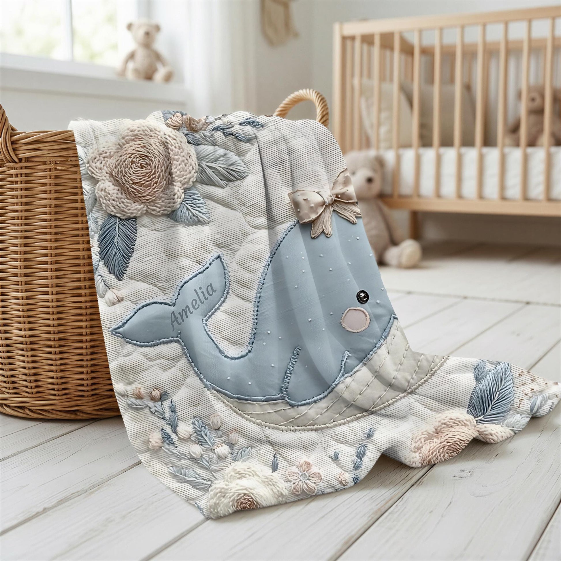 This embroidered look baby blanket features a gentle whale with a delicate bow, surrounded by soft floral elements in calming blue, cream, and natural tones.
