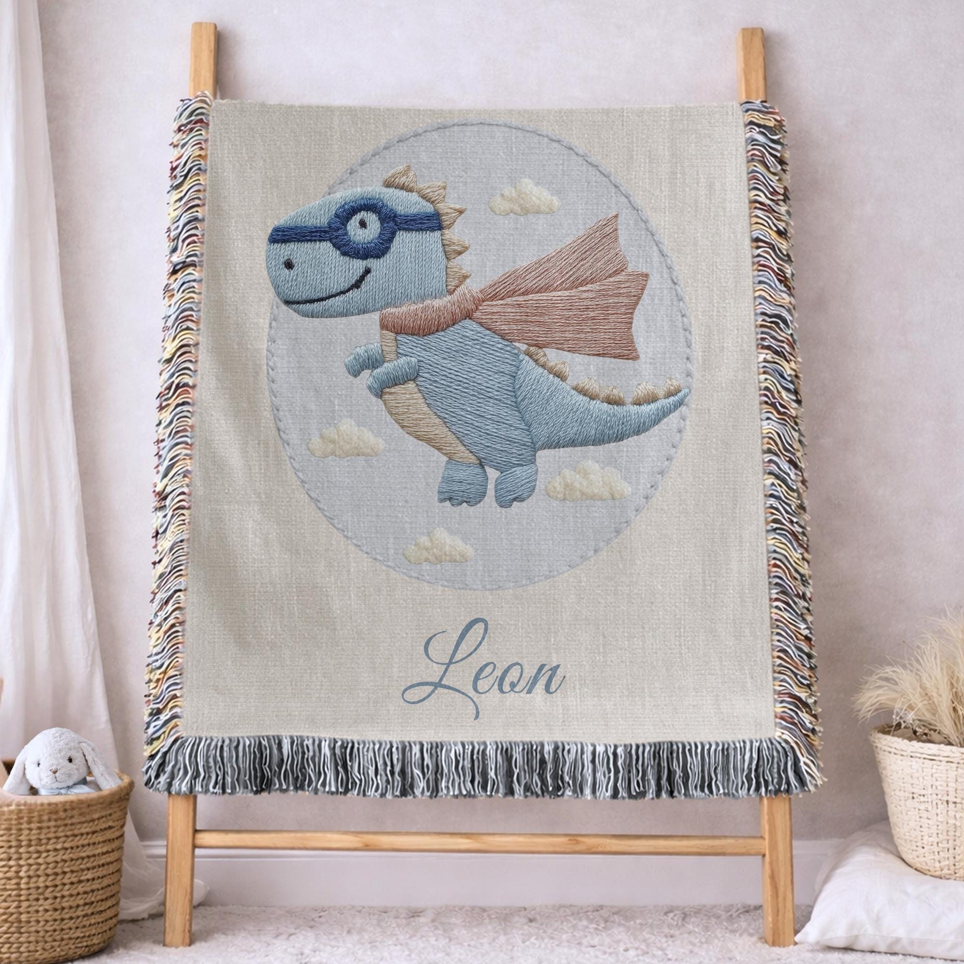 Personalized dinosaur woven baby blanket in 100% cotton. Embroidered-look superhero dino design, custom name keepsake for nursery decor.