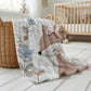 Fox baby blanket with an elegant embroidered-look fox and soft florals in muted blue, peach and ivory tones. A cozy neutral nursery blanket and timeless baby gift.