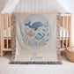 This personalized woven baby blanket features a gentle ocean theme with a sweet whale and fish design in a soft embroidered-look style.