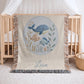 This personalized woven baby blanket features a gentle ocean theme with a sweet whale and fish design in a soft embroidered-look style.