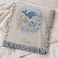This personalized woven baby blanket features a gentle ocean theme with a sweet whale and fish design in a soft embroidered-look style.