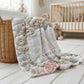 Personalized floral monogram baby blanket with elegant embroidered-look design. Soft, cozy fabric in calm neutral tones — a timeless nursery gift.