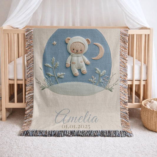 Personalized astronaut teddy woven blanket made from 100% cotton. A calm space-themed nursery design with a teddy bear in an astronaut suit, woven in an embroidered-look finish — custom name and optional birth date included.