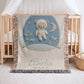 Personalized astronaut teddy woven blanket made from 100% cotton. A calm space-themed nursery design with a teddy bear in an astronaut suit, woven in an embroidered-look finish — custom name and optional birth date included.