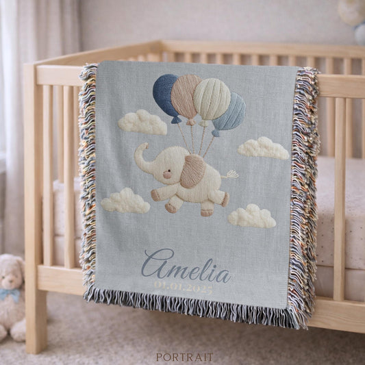 Personalized elephant woven blanket made from 100% cotton. A soft sky-themed nursery design featuring a baby elephant floating with balloons, woven in an embroidered-look finish — custom name and optional birth date included.
