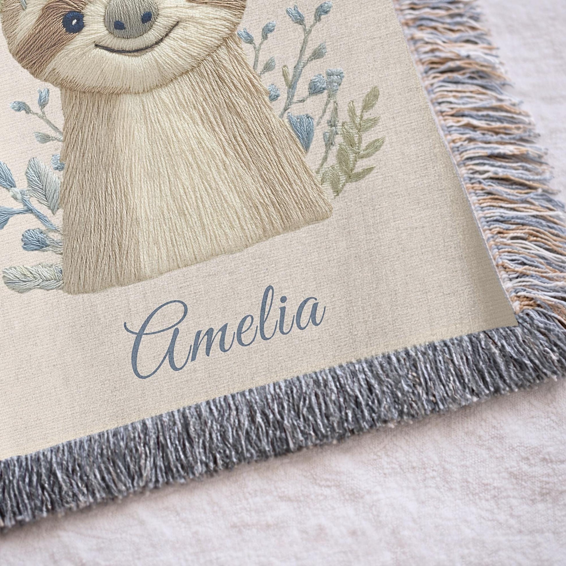 Woven cotton baby blanket with a calm sloth design. Personalized with name, neutral nursery decor and a timeless heirloom newborn gift.