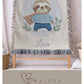 Personalized woven cotton baby blanket featuring a cute superhero sloth. Embroidered-look design, custom name, timeless nursery decor.