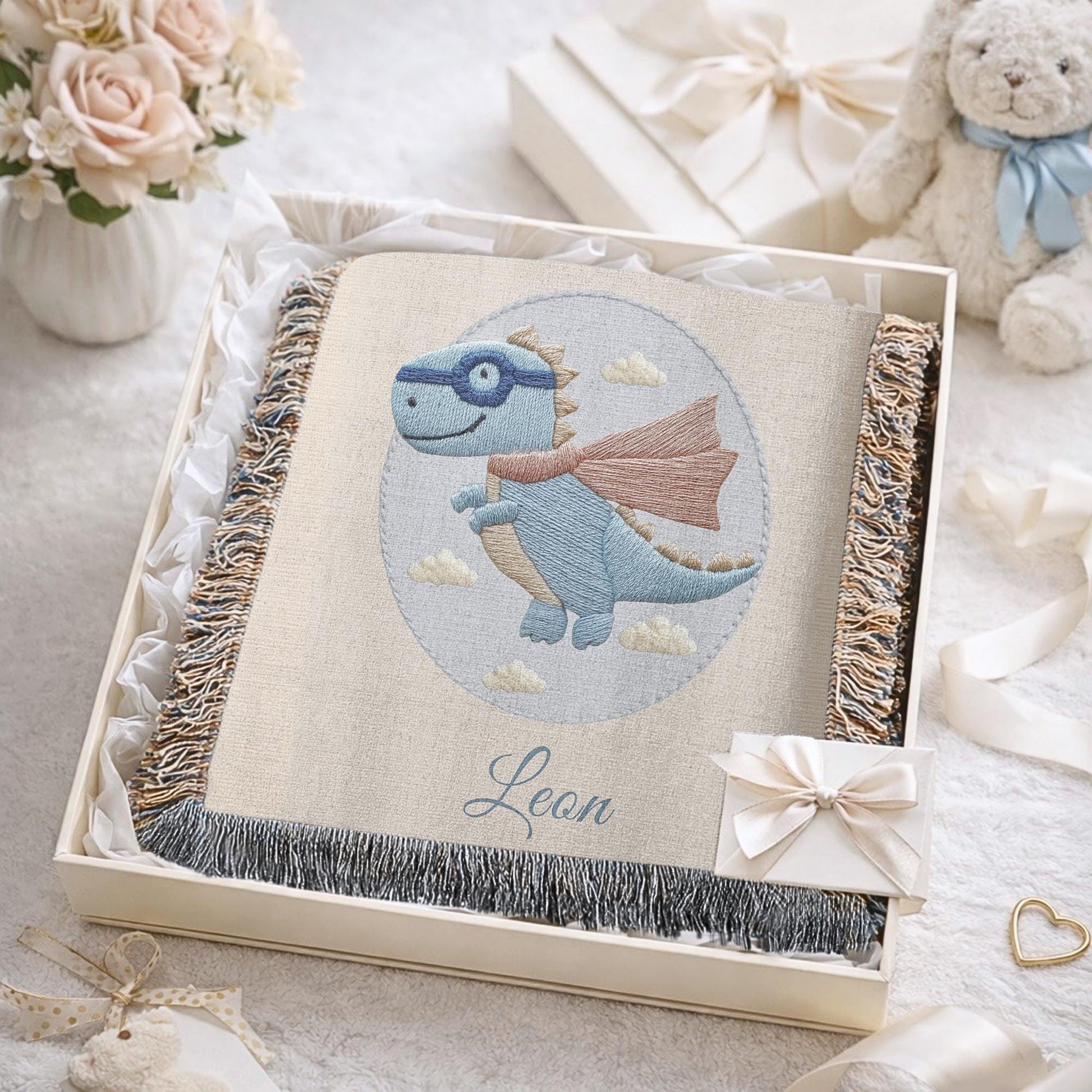 Personalized dinosaur woven baby blanket in 100% cotton. Embroidered-look superhero dino design, custom name keepsake for nursery decor.