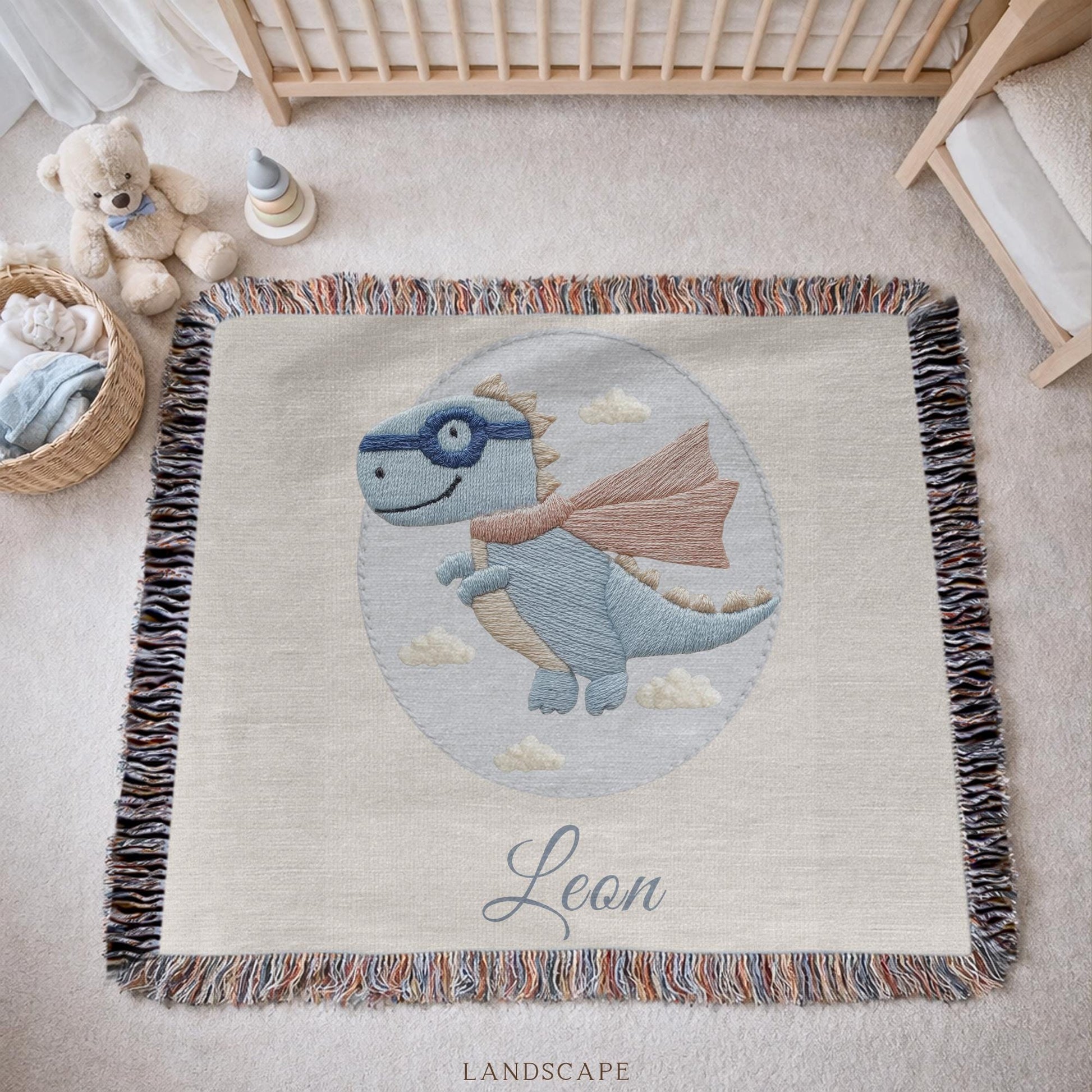 Personalized dinosaur woven baby blanket in 100% cotton. Embroidered-look superhero dino design, custom name keepsake for nursery decor.