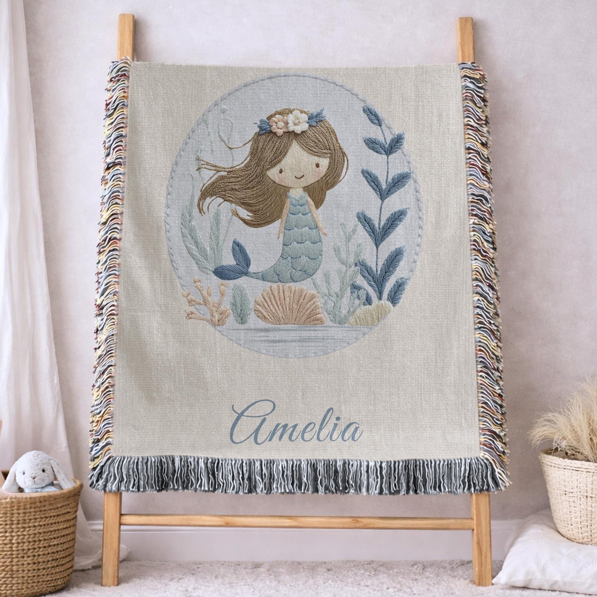 Personalized woven baby blanket featuring a calm mermaid design. Ocean under the sea nursery decor, crafted as a soft cotton tapestry keepsake.