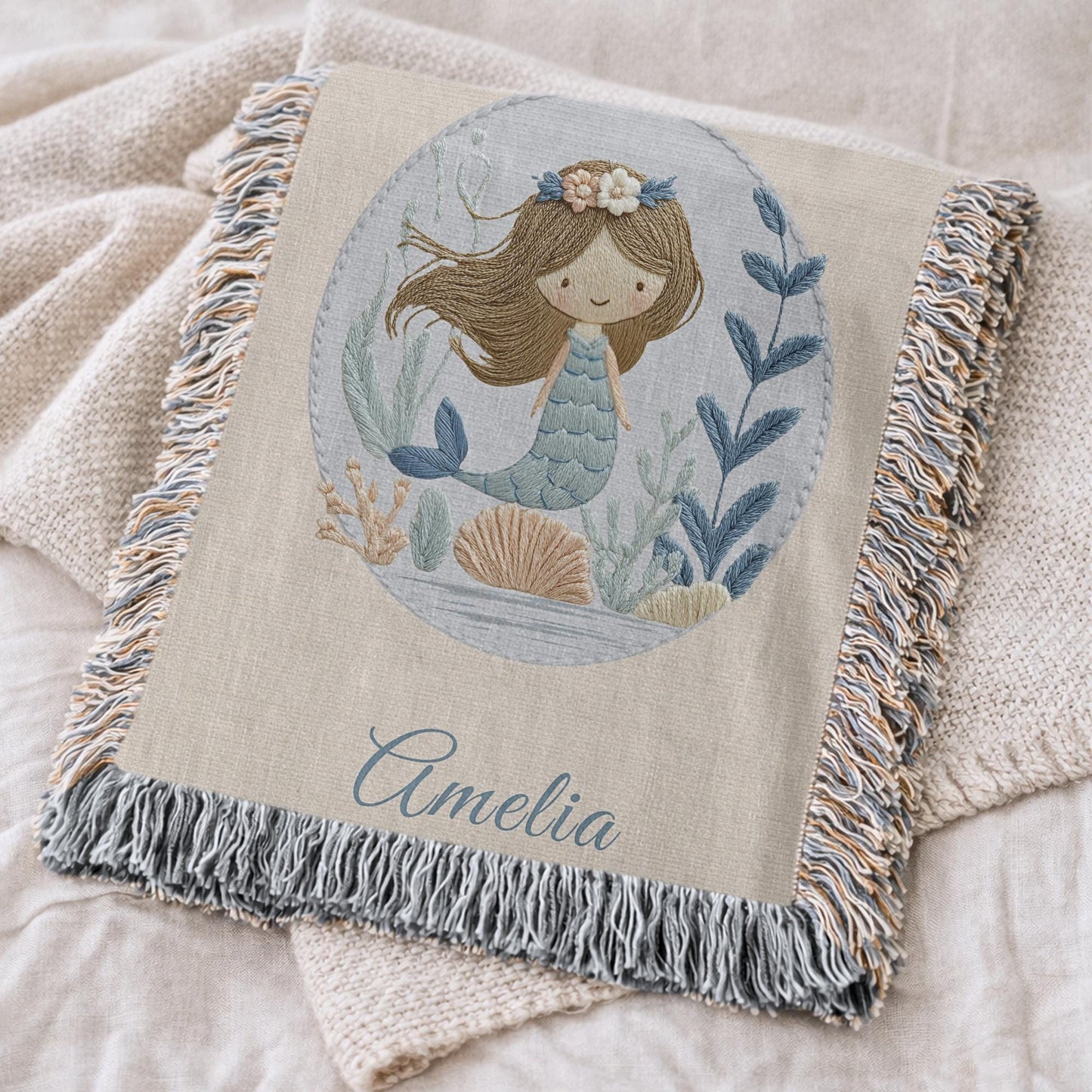 Personalized woven baby blanket featuring a calm mermaid design. Ocean under the sea nursery decor, crafted as a soft cotton tapestry keepsake.