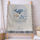This personalized woven baby blanket features a gentle ocean theme with a sweet whale and fish design in a soft embroidered-look style.
