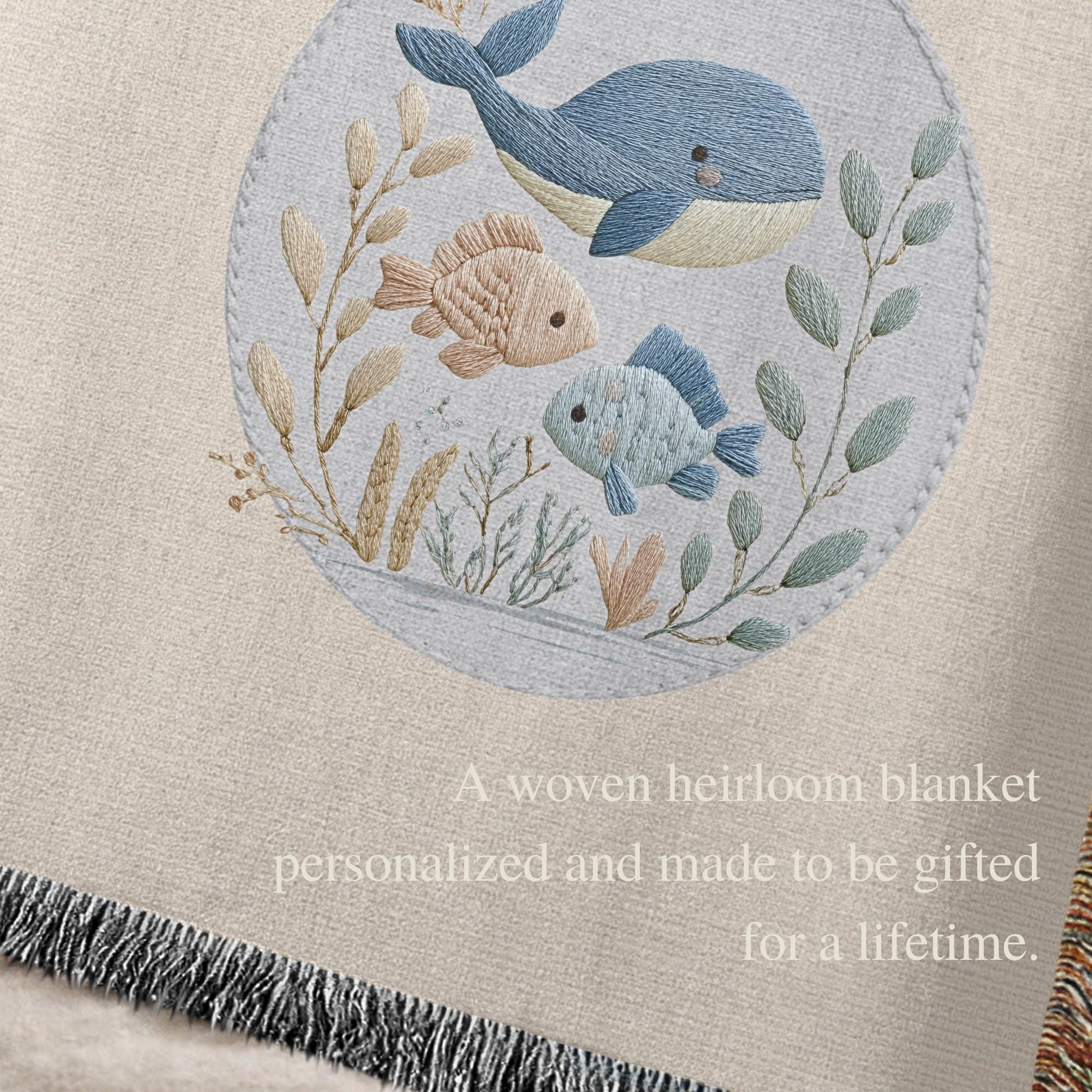 This personalized woven baby blanket features a gentle ocean theme with a sweet whale and fish design in a soft embroidered-look style.