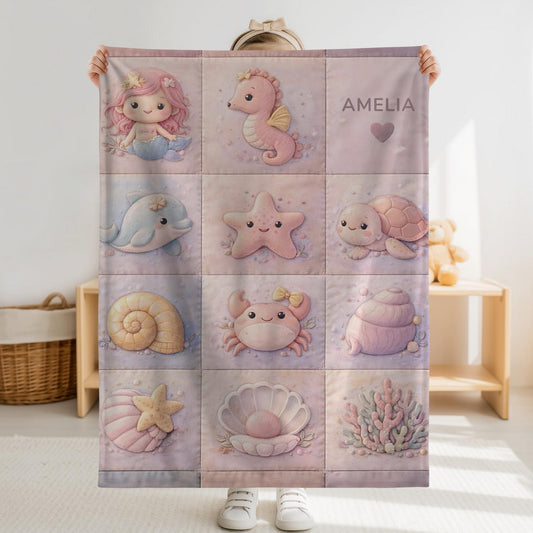 A personalized pink ocean baby quilt blanket with your baby’s name, designed in a soft patchwork look with gentle mermaid-inspired sea motifs.