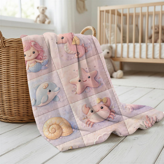 A personalized pink ocean baby quilt blanket with your baby’s name, designed in a soft patchwork look with gentle mermaid-inspired sea motifs.