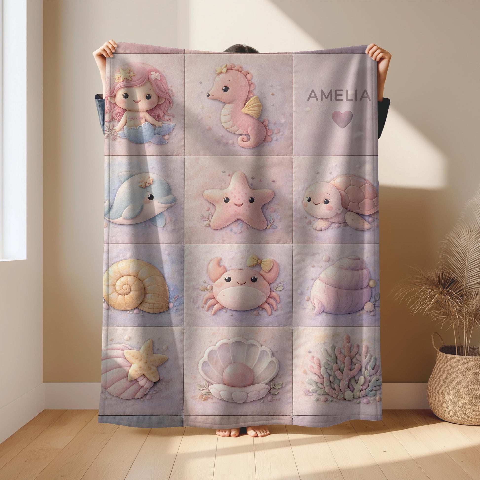 A personalized pink ocean baby quilt blanket with your baby’s name, designed in a soft patchwork look with gentle mermaid-inspired sea motifs.