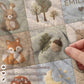 Personalized woodland baby blanket with forest patchwork quilt look in soft neutral colors. Cozy newborn blanket and boutique nursery gift.