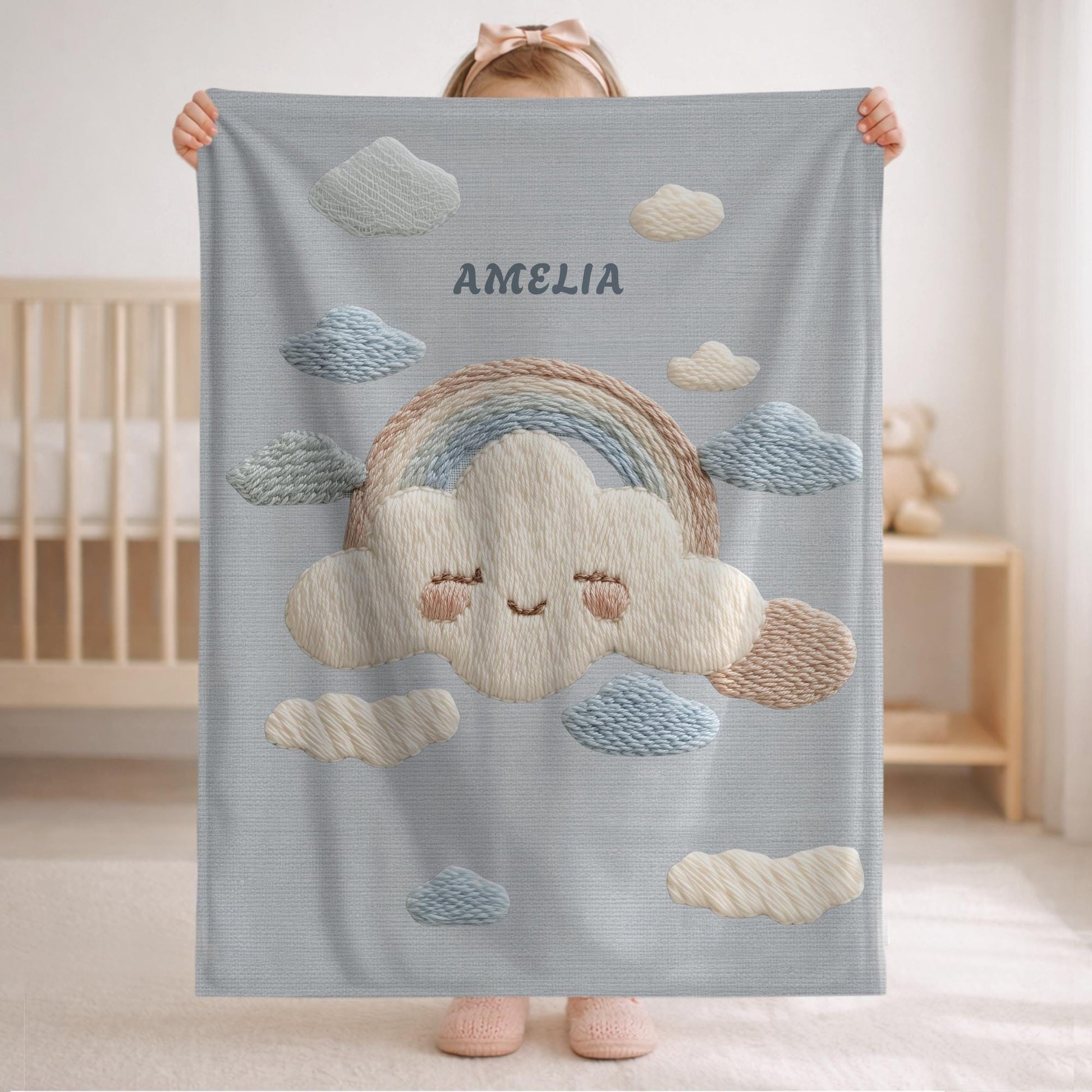 Personalized baby blanket with name in an embroidery look featuring a cloud with rainbow. Soft pastel tones – cozy velveteen or minky microfiber.