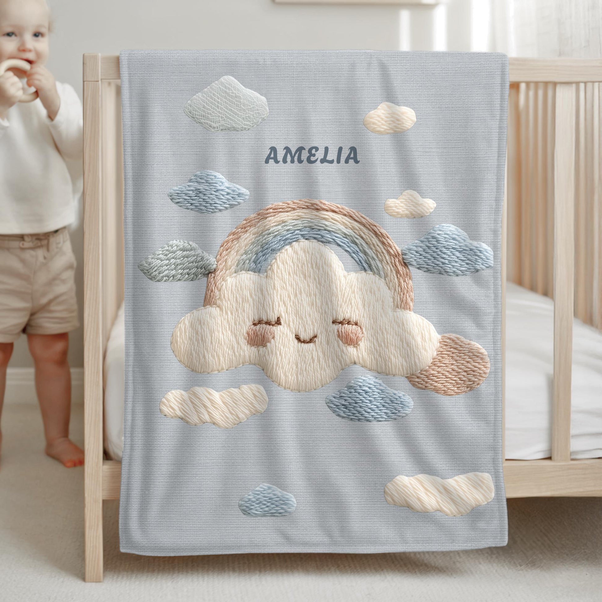 Personalized baby blanket with name in an embroidery look featuring a cloud with rainbow. Soft pastel tones – cozy velveteen or minky microfiber.