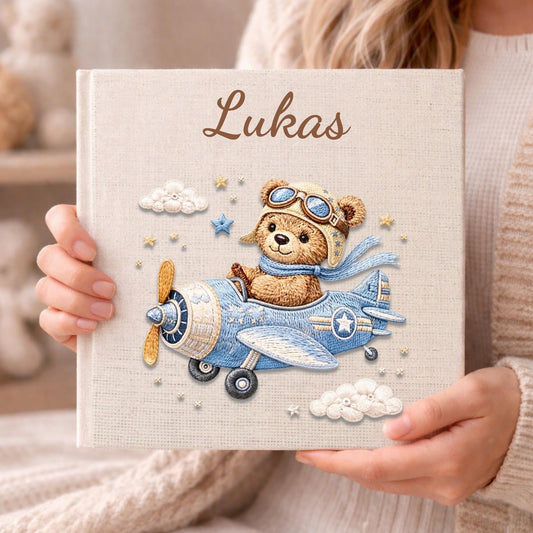 Personalized teddy bear airplane baby memory book with name and birth date. A soft aviation nursery album for first memories and milestones.
