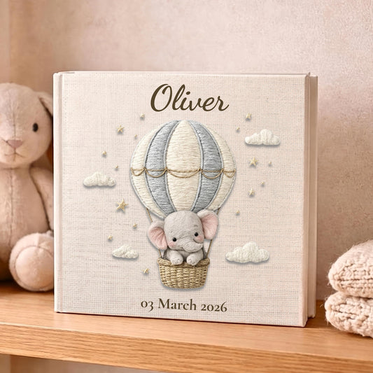 Personalized elephant baby memory album with hot air balloon design, custom name and optional birth date. A neutral nursery keepsake and timeless newborn photo book.