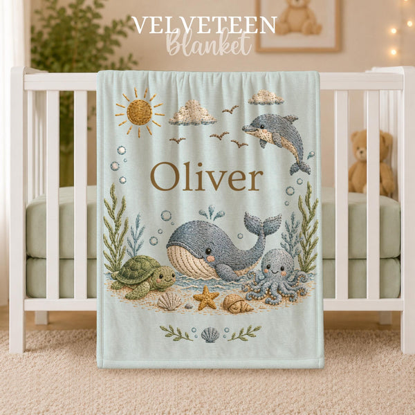 Personalized Ocean Baby Blanket with an embroidered-look print featuring a whale, dolphin, sea turtle, octopus, and coastal details.