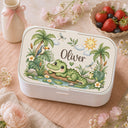 Personalized Crocodile Bento Lunch Box featuring a charming watercolor fine art print with a sweet crocodile, tropical palm trees, a toucan, frog, dragonflies, water lilies and a smiling sun. Customized with your child’s name, this practical kids lunchbox is perfect for daycare, preschool, kindergarten, school, picnics and everyday adventures.