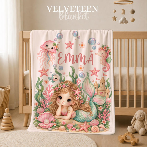 Personalized Mermaid Baby Blanket featuring a sweet little mermaid surrounded by seashells, starfish, coral, bubbles, flowers, a seahorse, jellyfish and a magical sandcastle. Customized with your baby’s name, this dreamy underwater blanket makes a beautiful addition to a baby girl nursery and a special keepsake for a precious new arrival.